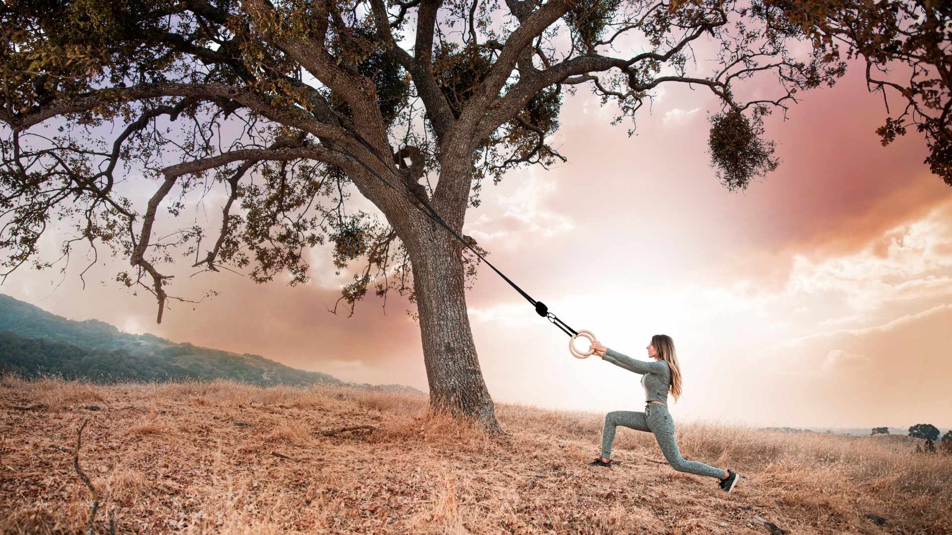 Image of the BGR being used by a woman at sunset using a tree